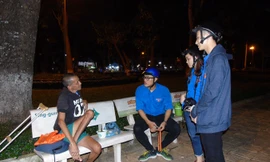 Các bạn ngồi trò chuyện với ông Hùng tại công viên nơi ông sống 4 năm nay. Ảnh: Kim Hà.