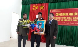 Đại diện gia đình ông Sường nhận hoa chúc mừng của lãnh đạo địa phương