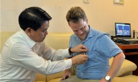 Chủ tịch Nguyễn Đức Chung gắn lên ngực áo anh James Joseph Kendall logo của thành phố Hà Nội.