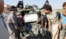 Các tay súng IS thu lượm mảnh xác máy bay quân đội Syria