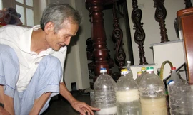 Ông Nguyễn Phúc Thanh bên cạnh các bình thí nghiệm làm bột giấy