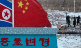 Cảnh sát Trung Quốc xây tường rào gần cột mốc bê tông vẽ cờ Trung Quốc và Triều Tiên với dòng chữ “Biên giới Trung Quốc - Triều Tiên”. Ảnh: AP