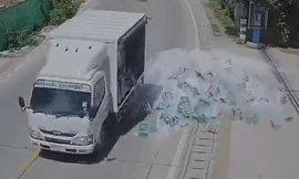 Xe tải ôm cua đánh rơi hàng trăm chai bia xuống đường
