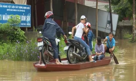 Bi hài mùa lũ: Chèo thuyền chở xe máy qua quốc lộ bị ngập
