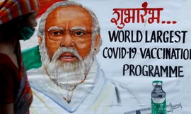 Một người phụ nữ bước qua bức tranh chân dung Thủ tướng Ấn Độ Narendra Modi. Ảnh: Reuters