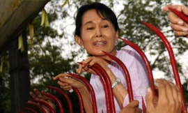 Bà Aung San Suu Kyi - người từng bị quản thúc tại gia suốt nhiều năm - chào những người ủng hộ hồi năm 2010. Ảnh: EPA