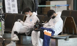 Sinh viên Trung Quốc mặc đồ bảo hộ đang chờ xe đưa đón đặc biệt sau khi đến sân bay Quốc tế Incheon, phía tây Seoul, vào ngày 25/2. Ảnh: Yonhap