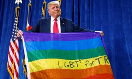 Tổng thống Mỹ Trump cầm lá cờ 7 màu của cộng đồng LGBTQ. Ảnh: Reuters