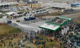 Lực lượng an ninh Ba Lan phun vòi rồng vào người di cư ở biên giới Belarus sau khi nhóm người này ném sỏi đá, chai lọ qua hàng rào. Ảnh: Reuters