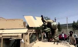 Tay súng Taliban đứng trên nóc xe Humvee của Mỹ ở Kabul. Ảnh: Reuters