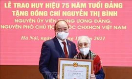 Chủ tịch nước Nguyễn Xuân Phúc trao tặng huy hiệu 75 năm tuổi Đảng cho đồng chí Nguyễn Thị Bình, nguyên Phó Chủ tịch nước CHXHCN Việt Nam.