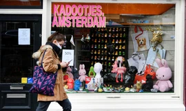 Một người phụ nữ đeo khẩu trang đi bộ ở Amsterdam (Hà Lan). Ảnh: Reuters