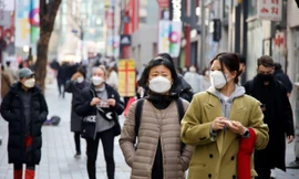 Người dân Seoul đeo khẩu trang đi dạo phố. Ảnh: Reuters