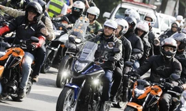 Ông Bolsonaro (lái xe, ở giữa) đội mũ bảo hiểm nhưng không đeo khẩu trang. Ảnh: AP