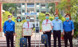 Anh Trần Bảo Lâm - Phó Bí thư Tỉnh Đoàn, Chủ tịch Hội đồng Đội tỉnh Bình Dương biểu dương trao khen thưởng cho hai tác giả bên cạnh sáng chế thiết bị "3 trong 1". Ảnh: TĐBD