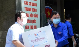 Anh Nguyễn Anh Tuấn và các đoàn viên thanh niên chuyển các thùng quà lên xe đến với các vùng dịch. Ảnh: Xuân Tùng