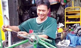 Anh Lê Văn Thái lắp ráp xe đạp cũ tặng người nghèo. Ảnh: Trọng Thịnh.