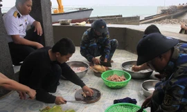 Các chiến sĩ đảo Tốc Tan A làm cơm trong ngày mưa bão. Ảnh: Trường Phong.