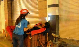 Thành viên Đội CTXH của HUTECH phát cháo cho người lao động nghèo trong đêm. Ảnh: Đội Công tác xã hội HUTECH cung cấp.