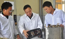 Đại úy Nguyễn Phi Hùng (ngoài cùng bên phải) trao đổi với lãnh đạo đơn vị về nguyên lý hoạt động của thiết bị chống khủng bố H-03.