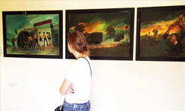 Du khách xem những bức tranh tái hiện cảnh tra tấn tại “Cánh đồng chết”.