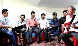 Anh Hưng (cầm micro) và các thành viên ban nhạc đang tập luyện.