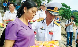Thân nhân liệt sĩ tàu C235 thả hoa tưởng niệm các liệt sĩ. Ảnh: Hồng Vĩnh.