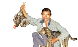 Ông Ksor Lưg vui mừng khi chú chó săn được con gà rừng.