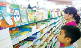 Phụ huynh cùng con lựa chọn mua sách giáo khoa tại một hiệu sách ở Hà Nội. Ảnh: Ngọc Châu.