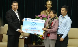 Chủ tịch UBND Đà Nẵng Huỳnh Đức Thơ trao nhà cho mẹ con bà Nguyễn Thị Tần - vợ liệt sĩ Vũ Phi Trừ.