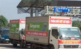 Người dân treo biểu ngữ, cho xe diễu hành qua trạm thu phí Bờ Đậu để phản đối thu phí. Ảnh: A.T.