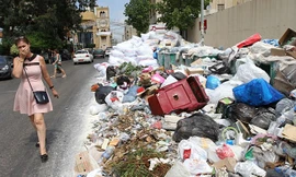 Một phụ nữ bịt mũi đi qua bãi rác thải tạm thời ở Jdeideh, phía đông bắc thủ đô Beirut của Li-băng. Ảnh: Getty Images.