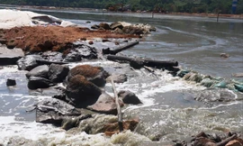 Nước rỉ đen ngòm từ túi bùn chảy về hướng vịnh Chân Mây.