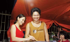 Anh Bình chị Loan trong quán ăn “câm điếc” mưu sinh của mình. Ảnh: Thanh Trần.