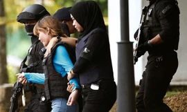 Đoàn Thị Hương được hộ tống ra khỏi phiên tòa. Ảnh: CNA.