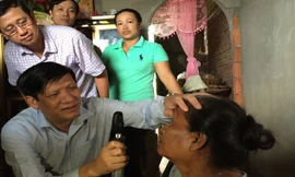 Thứ trưởng Nguyễn Thanh Long kiểm tra mắt cho bệnh nhân Lý Thị Hiên. Ảnh: L.N.