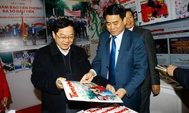 Ông Lê Xuân Sơn (trái) Tổng Biên tập báo Tiền Phong giới thiệu ấn phẩm đặc biệt tết Bính Thân của Báo Tiền Phong với ông Nguyễn Đức Chung - Ủy viên TƯ Đảng - Chủ tịch UBND TP Hà Nội.