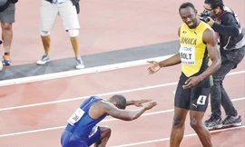 Nhà vô địch Justin Gatlin quỳ gối tỏ lòng ngưỡng mộ với Usain Bolt sau lần cuối cùng tia chớp người Jamaica sải bước trên đường chạy 100m. Ảnh: AP.
