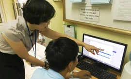 Cán bộ một cửa phường Thụy Khuê Vũ Thu Giang hướng dẫn người dân truy cập dịch vụ công trực tuyến. Ảnh: Anh Trọng.