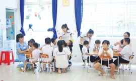 Giáo viên đặc biệt cho trẻ ăn trưa​. Ảnh: Ngô Tùng.