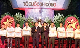 Thủ tướng Nguyễn Xuân Phúc và Trưởng ban Tổ chức Trung ương Phạm Minh Chính trao Bằng Tổ quốc ghi công cho đại diện thân nhân các liệt sỹ. Ảnh: Thống Nhất.