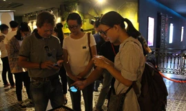 Người xem triển lãm trải nghiệm công nghệ 3D AR Art và thích thú khi hình ảnh cầu Rồng, cầu sông Hàn... hiện lên chân thực từ mọi góc độ. Ảnh: Giang Thanh.