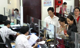 Cán bộ phòng Thuế Thành phố Hồ Chí Minh đang làm thủ tục nộp thuế của dân. Ảnh: Hồng Vĩnh.