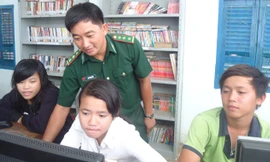 Thượng úy Bao Minh Tiến hướng dẫn các em tham gia “Lớp tin học cộng đồng Thiềng Liềng”.