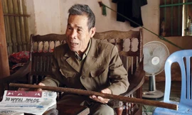 Ông Quán bồi hồi kể lại những kỷ niệm cùng chiếc gậy Trường Sơn. Ảnh: Dương Lê.