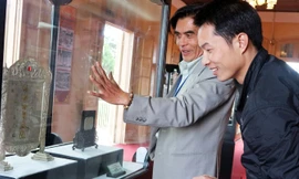 Giám đốc bảo tàng (bên trái) nói về bức trấn phong “vạn thọ tứ tuần Đại Khánh”.