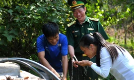 Niềm vui của người lính biên phòng Pò Mã và người dân thôn Nà Lẹng bên bể nước sạch trong thôn. Ảnh: Xuân Tùng.