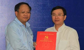 Phó bí thư thường trực Thành ủy TPHCM Tất Thành Cang (bên trái) trao quyết định phân công ông Đặng Quốc Toàn làm Bí thư Quận ủy Q.10