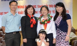 Nga Nhi cùng gia đình và cô giáo chủ nhiệm sau một lần nhận giải thưởng quốc tế.