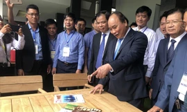 Thủ tướng Nguyễn Xuân Phúc và các đại biểu thăm gian hàng bày sản phẩm gỗ. ẢNH: PV.